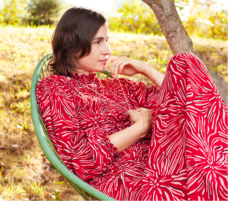 Martina Adamcová sedící v zahradním křesle, hledí do dáli a přemýšlí